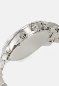 Silver stainless steel watch with a round case, two side buttons, and a textured bezel, featuring a link bracelet and smooth polished finish.