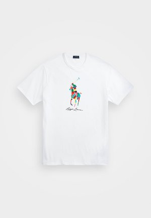T-shirt blanc à manches courtes avec un logo multicolore de joueur de polo et la signature "Ralph Lauren" imprimée sous le logo.