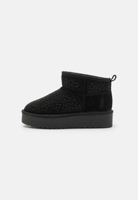 Botine negre la glezna, din suede, cu o suprafață texturată împodobită cu mici mărgele și o talpă groasă neagră. Au un loop pentru a fi ușor de încălțat.