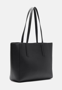 Borsa tote nera in pelle con due manici lunghi, forma rettangolare, superficie testurizzata e design minimalista senza hardware o accenti visibili.