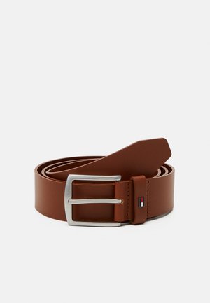 Ceinture en cuir marron avec une boucle en argent. Présente une texture lisse et un accent cousu près de la boucle, avec un détail de logo.