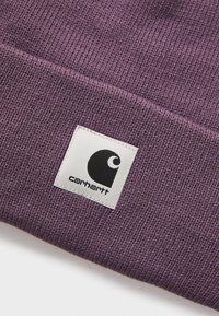 Paarse gebreide Carhartt-beanie met wit vierkant label voorzien van zwart Carhartt-logo en tekst op de opgerolde manchette.