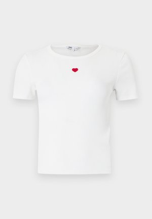 T-shirt blanc à manches courtes côtelées avec un petit cœur rouge brodé au centre de la poitrine, sous l'encolure.