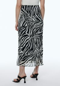 Zebra-gepatroneerde midi-rok van lichtgewicht stof in zwart en crèmekleur, met een zijspleet en een gladde afwerking.
