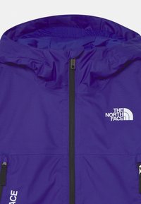 Purple rain jacket featuring a zip closure, adjustable hood, and the white North Face logo on the left chest. Smooth, lightweight fabric.