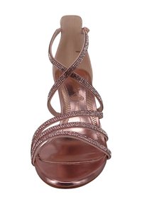 Ruusu kullanvärinen korkokenkä, jossa on ristikkäin nauhat, joita koristavat strassit. Avoin varvasosa ja sileä, kiiltävä pinta. Tasapohja.