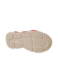 Suela de zapato en goma blanco roto con un diseño de agarre texturizado en patrón de diamante. Acentos rojos visibles en el borde superior.