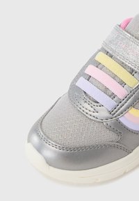 Gray athletic shoe featuring a mesh upper with glittery accents, colorful straps in pink, yellow, and purple, and a white rubber sole.