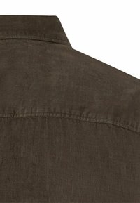 Brązowa koszula z korduroju z klasycznym kołnierzykiem, teksturowanym materiałem i widocznym szwem wzdłuż szwu na ramieniu oraz dekolcie z tyłu.