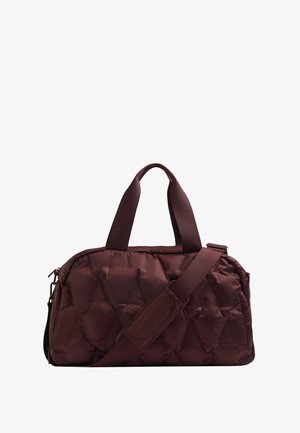 Pufasti bordo torbica s dvostrukim ručkama i odvojivim remenom za rame. Ima kviltanu teksturu i zatvaranje na patentni zatvarač.