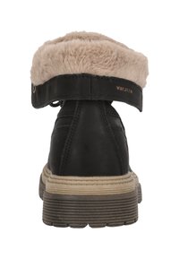 Svart ankelsko med fuskpäls vid kanten, med en texturerad läderövre del, beige gummisula och subtila sömdetaljer.