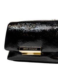 Clutch bag nera lucida con finitura testurizzata, dotata di chiusura in metallo dorato e placca del marchio incisa, forma rettangolare.