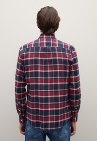 Rot kariertes Flanellhemd in Marineblau mit langen Ärmeln, Knopfmanschetten, einem Kragen und einem abgerundeten Saum. Glatte Textur und taillierter Schnitt.