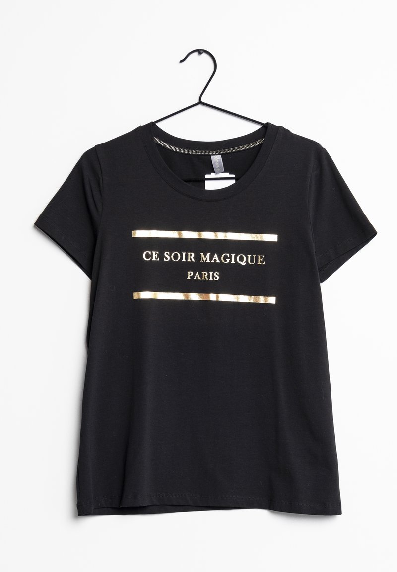 Svart T-shirt med kort ärm hängande på en galge med guldtexten "CE SOIR MAGIQUE PARIS" inramad av två horisontella guldlinjer framtill.