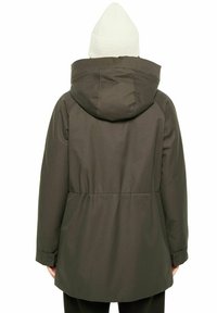 Olivgrön vattentät jacka med huva, med en åtdragen midja och elastiska ärmslut. I kombination med en vit stickad mössa.