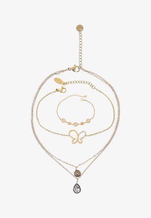 Gelaagd sieradenset in goudkleur met een vlinderontwerp, heldere steentjes en een druppelvormig hangertje. De kettingen variëren in lengte en structuur.