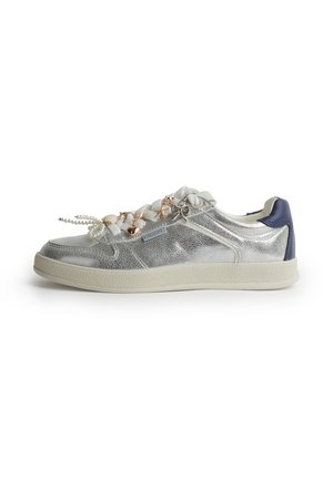 Sneaker argento low-top con suola bianca, tallone blu navy, lacci bianchi e charm decorativi in oro e perle sui lacci.
