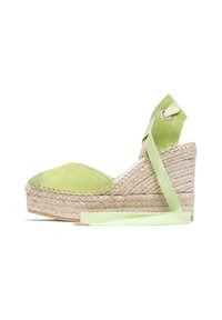 Espadrille à talon en daim vert avec une semelle en jute, présentant un bout arrondi et une bride de cheville avec un détail en ruban vert assorti.