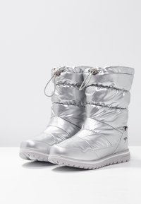 Stříbrné zateplené boty s prošívaným designem, uzávěrem na šňůrku a silnou, texturovanou podrážkou. Na boční straně je umístěno logo pro branding.