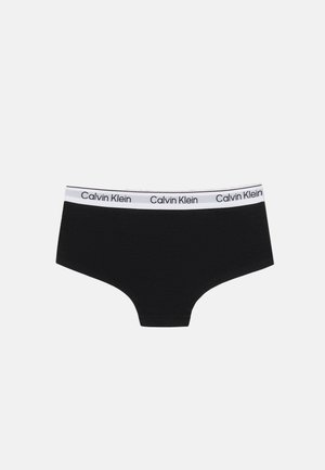 Musta Calvin Kleinin alushousut, joissa on valkoinen vyötärönauha ja toistuva musta "Calvin Klein" -tekstilogo, esitetty yksinkertaisella valkoisella taustalla.