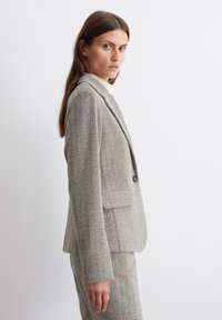 Grau-blazer mit Fischgrätenmuster, mit Reverskragen, einem einzigen Knopfverschluss und zwei vorderen Taschen, taillierte Passform und strukturierter Stoff.