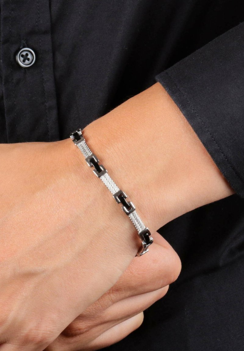 Bracciale da polso in argento e nero con anelli intrecciati, caratterizzato da una sezione in rete texturizzata. Finitura liscia e colori a contrasto.