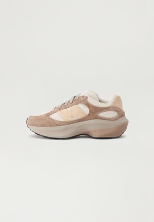 Running shoes with a tan suede and beige mesh upper, featuring a thick, light brown midsole and black rubber outsole, laced design.