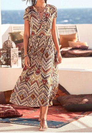Maxiklänning med V-ringning, korta ärmar och ett mönster av zickzack i jordnära toner. Lätt tyg ger ett luftigt och flödande rörelsemönster.