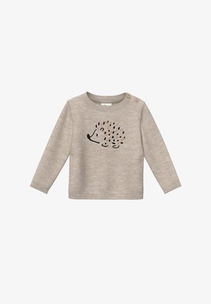 Beige langemouwtop in zachte stof, met een egeltje-druk en kleurrijke stippen, en twee knoopaccenten op de linkerschouder.