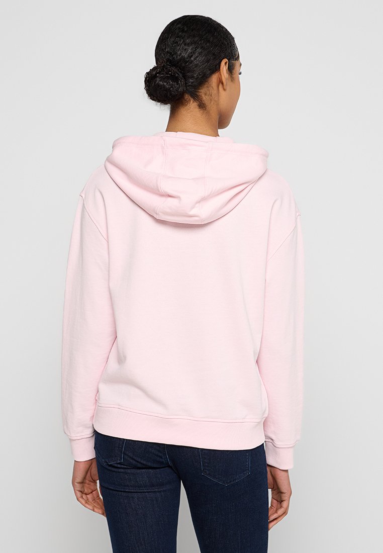 Hellrosa Kapuzenpullover mit Zugbandkapuze, gerippten Bündchen und Saum. Hergestellt aus weichem Baumwollstoff, mit lockerer Passform und ohne sichtbare Logos.