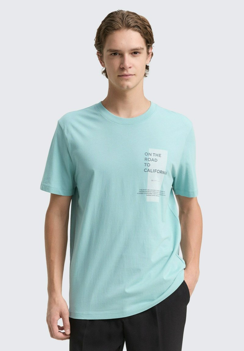Lichtblauwe katoenen t-shirt met korte mouwen, een ronde hals en een bedrukte grafiek met tekst aan de bovenlinkerkant.