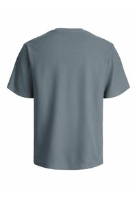 Kortærmet, løs pasform grå t-shirt med tekstureret stof, set fra ryggen, der fremhæver den runde hals og enkelheden i designet.