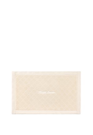 Tapis de bain rectangulaire de couleur crème avec motif matelassé en losange et "Ralph Lauren" brodé en blanc au centre.