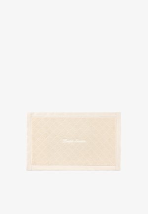 Tapis de bain rectangulaire de couleur crème avec motif matelassé en losange et "Ralph Lauren" brodé en blanc au centre.