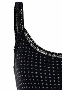Black knit bralette featuring small diamond patterns, lace trim on straps and neckline, with adjustable straps and a soft texture.
