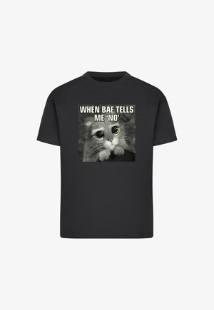 Svart bomull t-skjorte med grafikk av en kattunge med store øyne og teksten "NÅR BAE FORTELLER MEG 'NEI'". Korte ermer, standard passform.