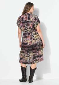 Tištěné šaty s krátkými rukávy, stahované v pase a s délkou ke kolenům. Mají abstraktní vícebarevný vzor v odstínech černé, růžové a zlaté.