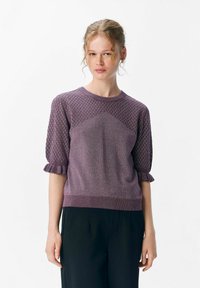 Fioletowy sweter z dzianiny z diamentowym wzorem na rękawach, krótkimi falbaniastego wykończeniami i gładką częścią. Miękka tekstura i dopasowany krój.