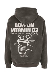 Ciemnoszara bluza z kapturem z białym napisem i ilustracjami ręki trzymającej filiżankę kawy z rogalikiem na górze. Miękka tekstura i swobodny design.