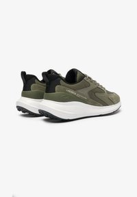 Green and black athletic shoes with a textured upper, lace-up design, and white cushioned sole, featuring the Lacoste logo on the side.
