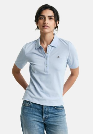 Hellblaues Poloshirt mit kurzen Ärmeln, Knopfleiste und gesticktem Logo auf der Brust. Der Stoff hat eine glatte Textur.