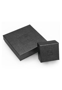 Zwei schwarze Geschenkboxen aus Karton übereinandergestapelt, eine große rechteckige und eine kleine quadratische. Beide zeigen ein dezentes geprägtes Logo.