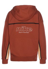 Nike hoodie i tegelröd, med en svart rand över axlarna och kontrasterande beige sidor, samt en stor logotyp tryckt på ryggen.