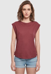 Burgunderfarget bomull T-skjorte med korte, rullede ermer, rund hals og avslappet passform. Stoffet ser mykt og glatt ut.