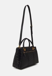 Schwarze gesteppte Handtasche mit goldfarbenen Beschlägen, zwei Schlaufenhenkeln und einem abnehmbaren Schultergurt; verfügt über eine vordere Reißverschlusstasche und ein Chevron-Muster.