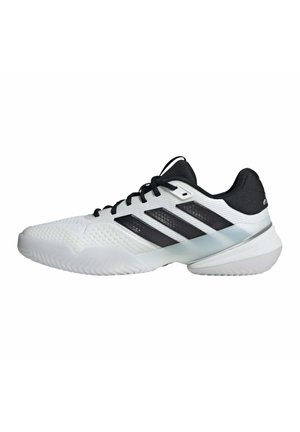 Weißer und schwarzer niedriger Sportschuh mit strukturierter Sohle und drei schwarzen Streifen an der Seite, in linkem Profil auf weißem Hintergrund dargestellt.