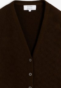 Cárdigan marrón hecho de hilo texturizado, con escote en V, cierre de botones y un patrón de diamantes en toda la tela.