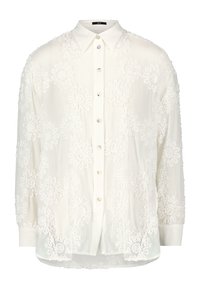 Chemise blanche à manches longues avec broderie florale. Elle présente un col à revers, des manches longues et une texture légèrement transparente. Boutons en nacre.