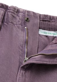 Pantalones de mezclilla morados con cierre de cremallera parcialmente abierto, botón de metal y etiqueta de ropa "TAYLOR-STRAIGHT" visible.