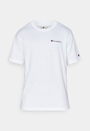 T-shirt bianco in cotone con collo a giro, maniche corte e un piccolo logo "Champion" in nero e rosso sul lato sinistro del petto.